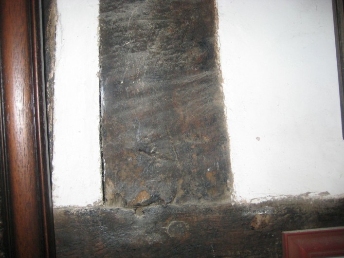 The original south western outside wall became an internal wall when the new wing was added preserving a series of carpenters marks marking the position of studs in the framework. This one is marked V.