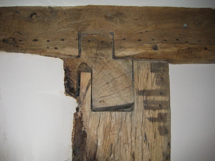 The original cross wing corner post showing section through the bressumer beam which has been cut away, and the overhanging cantilevered floor joists which are gently chamfered.