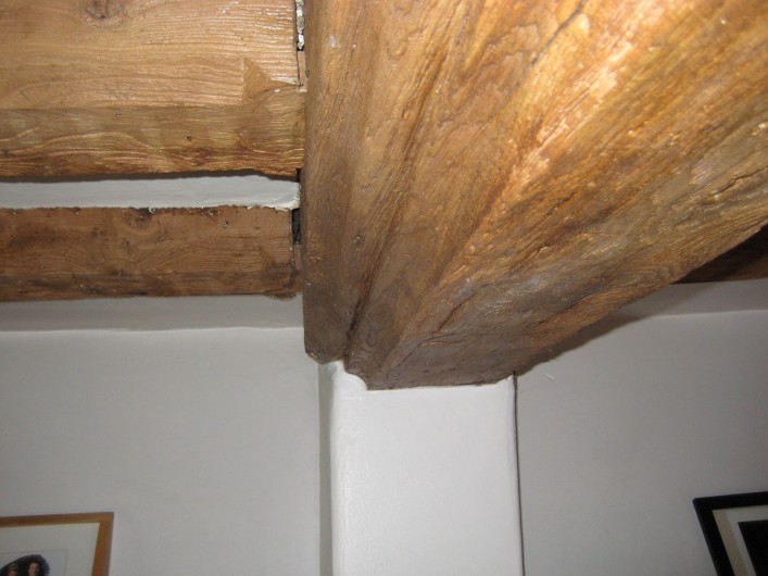 The heavily carved axial ceiling beam showing the chamfered floor joists with stop ends. This beam along with the similarly moulded fireplace timber may have been reused.