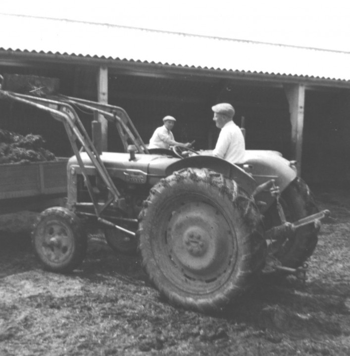 Late 1950s A Fordson Major tractor, lifting dung in the cattle yard of Elm Tree Farm. L-R: Ken Walker, Stan Walker