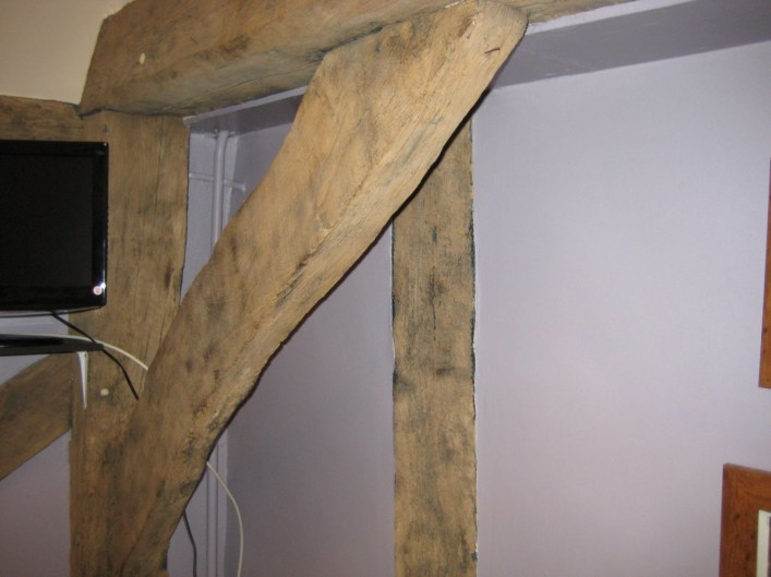 Former end wall shown by the tie beam and brace with the wall of the crosswing visible beyond. Although part of the tie beam is restricted from view, there is no sign of studs connecting into the tie beam. This may have been open to another bay which was demolished when the cross wing was built.